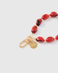 Close-up of ruby red agate beads showing dark smoky veining and translucent edges