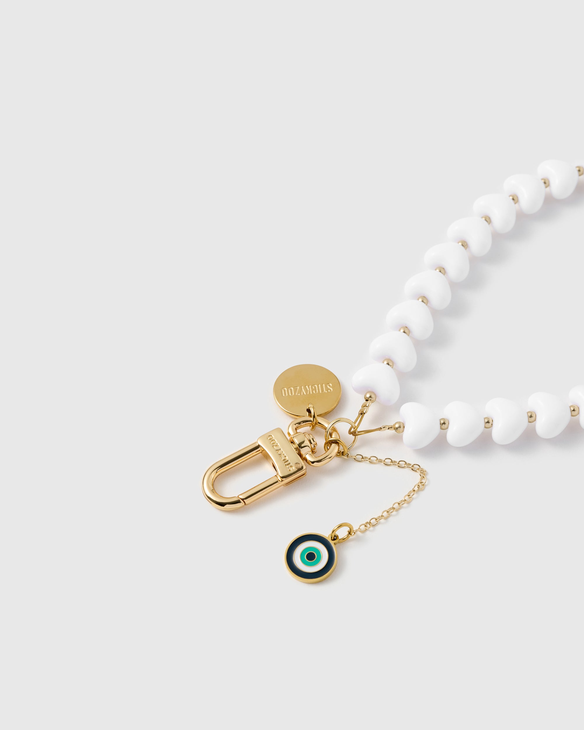 Close-up of 18K gold-plated lobster clasp and engraved STICKYZOO charm disc