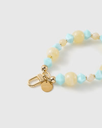 Close-up of the 18K gold-plated hook, engraved STICKYZOO disc and aqua marbled beads — no two alike