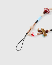 Close-up of molded dachshund figure with football bead and polka-dot mushroom accent