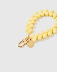 Yellow heart phone strap worn on wrist showing everyday hands-free carry