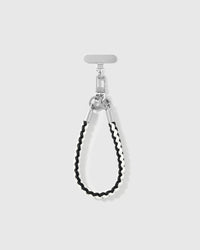 Ivory strap looped short as a wrist strap, showing the black and cream braided cord and silver-tone hardware