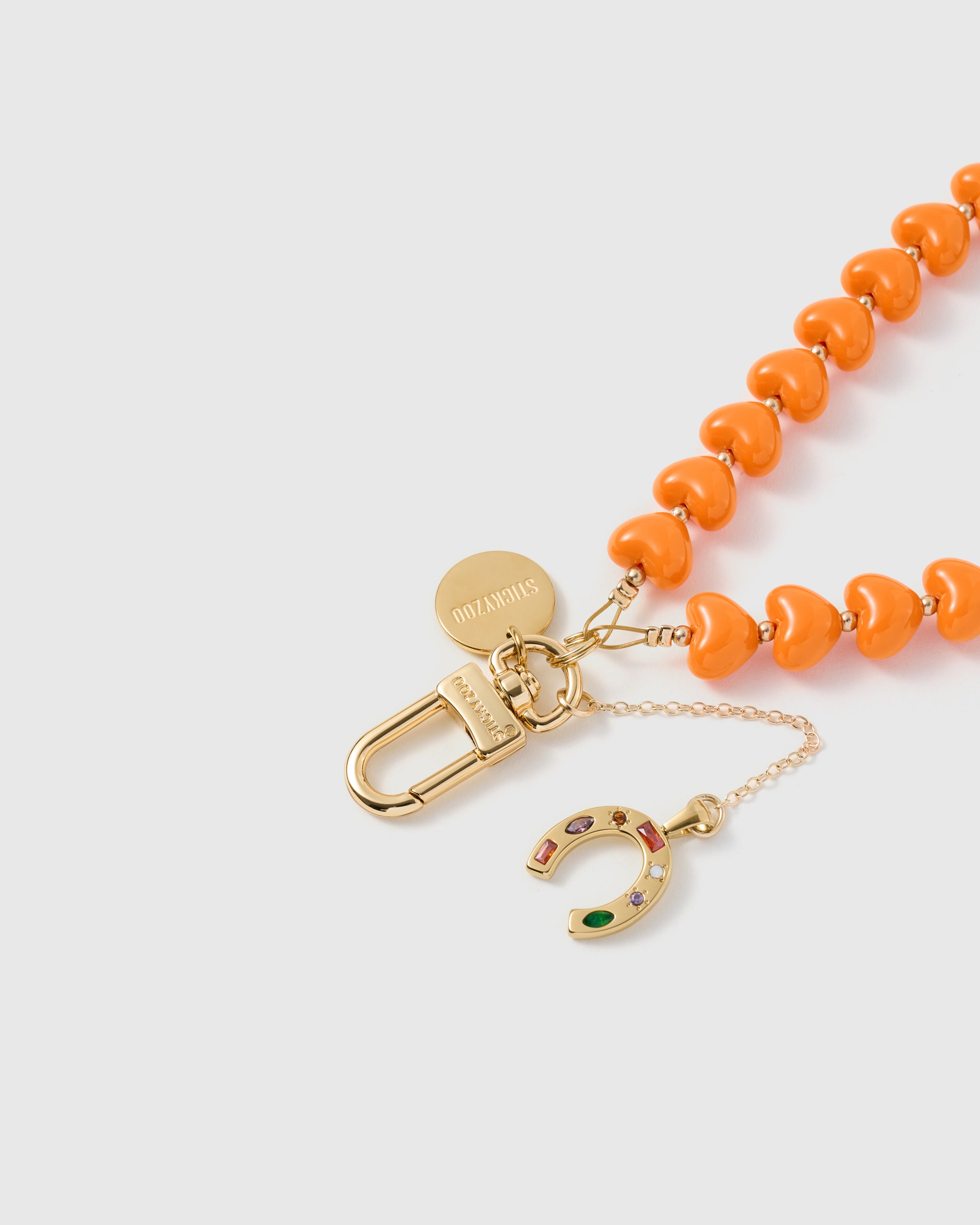 {Engraved STICKYZOO} 18K gold-plated carabiner and engraved disc on tangerine heart-bead strand