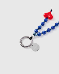 Close-up of silver-tone spring ring and engraved STICKYZOO disc with blue stone beads