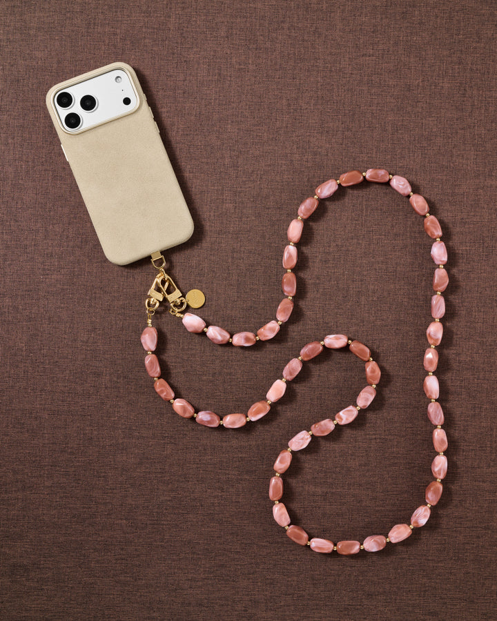 Dusty-rose beaded cross-body phone strap styled on fabric, handmade not factory