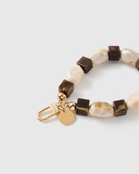 Close-up of the 18K gold-plated hook, engraved STICKYZOO disc and cocoa marbled beads — no two alike