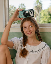 Slim midnight cat phone case showing the printed mint back panel and cat-face grip in daily use