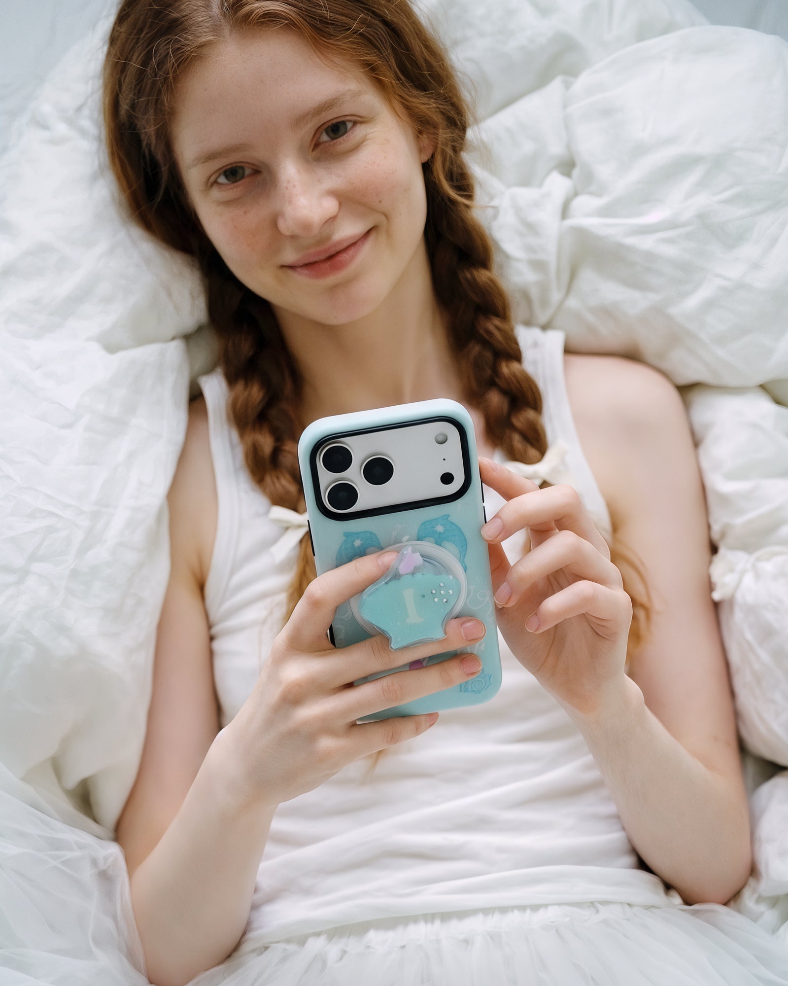Relaxed daily use of the aqua dolphin cove phone case with its glittered seashell grip on the back