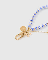 Close-up of gold-plated STICKYZOO clasp with blue porcelain beads and bow charm