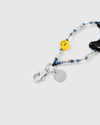 Close-up of glossy black heart bead and yellow smiley face bead with iridescent crystal accents