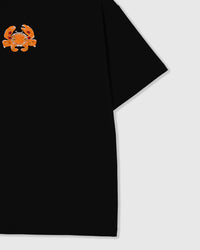 Close-up of the left chest and short sleeve of the black oversized Crab T-Shirt showing the beaded crab motif and relaxed boxy fit