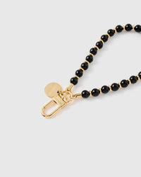 Close-up of gold-plated clasp and engraved STICKYZOO charm disc with glossy black beads