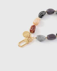 Close-up of gold-plated clasp and engraved STICKYZOO charm disc with mixed agate beads