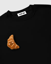 Model wearing STICKYZOO Double Croissant Sweatshirt in black showing dropped shoulders and relaxed silhouette
