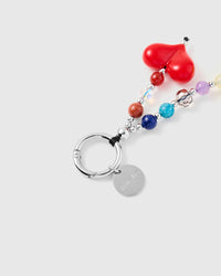 Close-up of yellow smiley face and red heart charms with colorful mixed beads