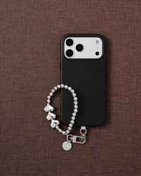 Phone with silver heart strap on styled background by STICKYZOO