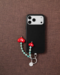 Phone with Jade Heart strap on brown fabric lifestyle flat-lay