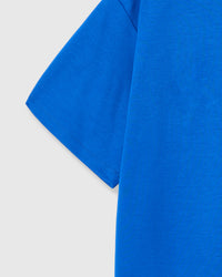 Model wearing STICKYZOO Shrimp Hug T-Shirt in blue showing dropped shoulders and shrimp placement