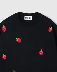 Close-up of collar area showing plush strawberry appliques on black cotton with STICKYZOO label