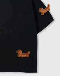 Detail of hand-stitched dachshund on black tee showing layered plush construction