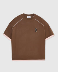Close-up of embroidered standing dachshund on brown cotton with visible thread-level stitch detail