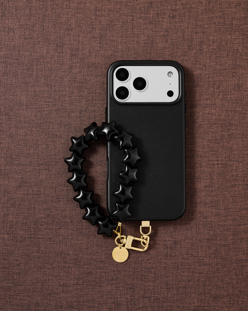 STICKYZOO noir star phone strap on warm flat-lay — Designed in Amsterdam