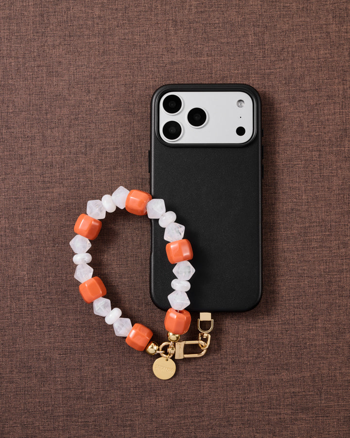 Clementine-orange bead phone strap styled on fabric, loved by thousands of STICKYZOO customers