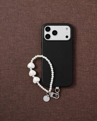Phone with pearl heart strap on styled background by STICKYZOO