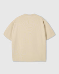 Back view of STICKYZOO beige Runaway Croissant T-Shirt showing boxy silhouette and ribbed neckline