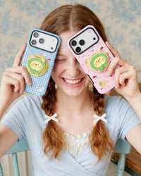 Blue and pink green-hood cat grip cases held up to frame the face, the cat-face medallions in clear view.