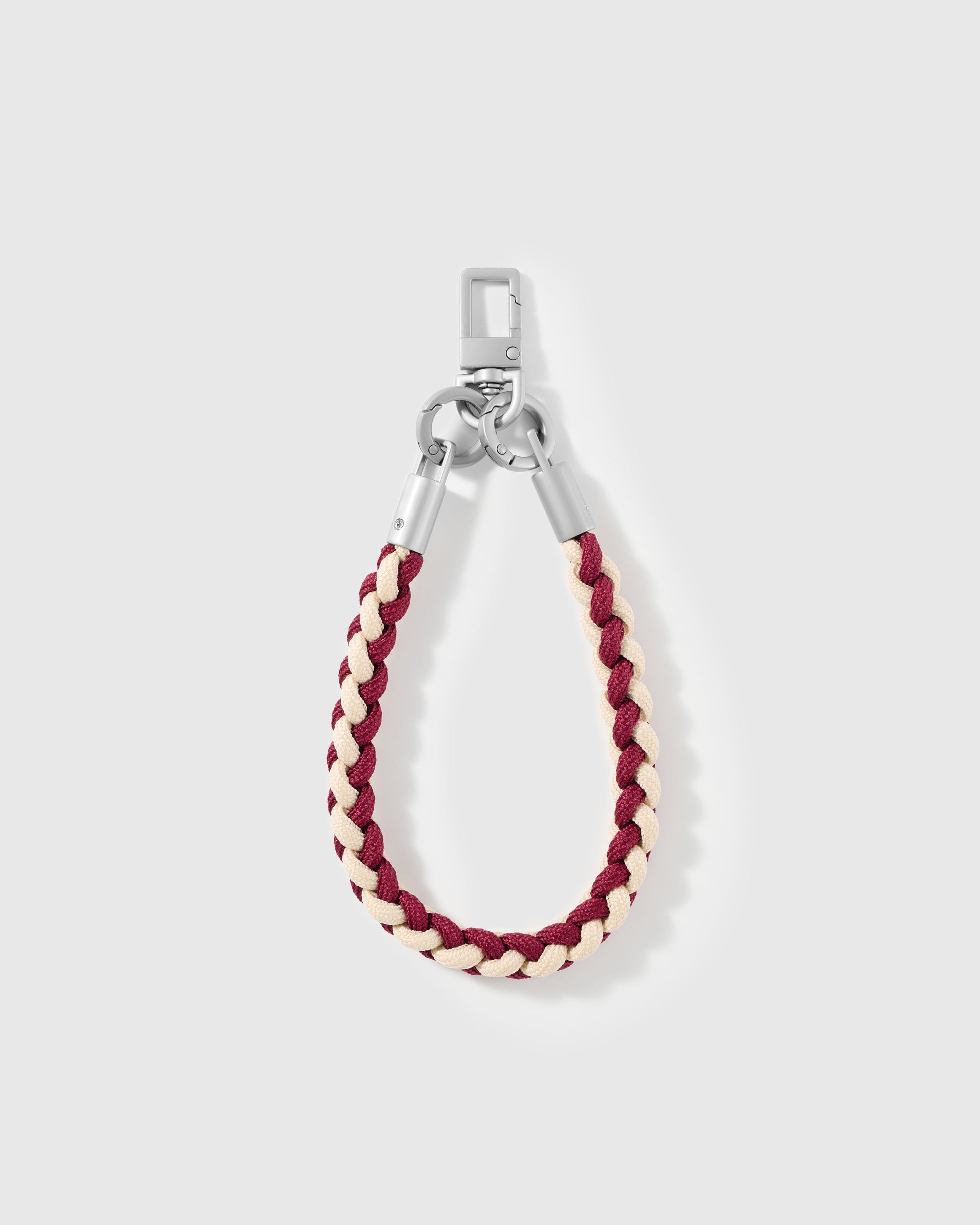 Detail of the burgundy and cream braided accent on the cross-body phone strap