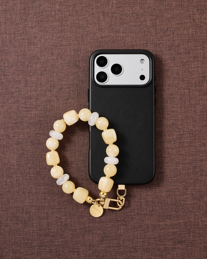 Buttermilk beaded phone strap styled on fabric, loved by thousands of STICKYZOO customers