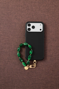 Emerald marble stone bead phone strap styled with phone on brown fabric flat-lay