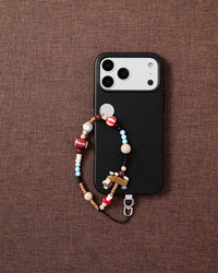 Sporty dog phone strap flat-lay on dark brown fabric by STICKYZOO