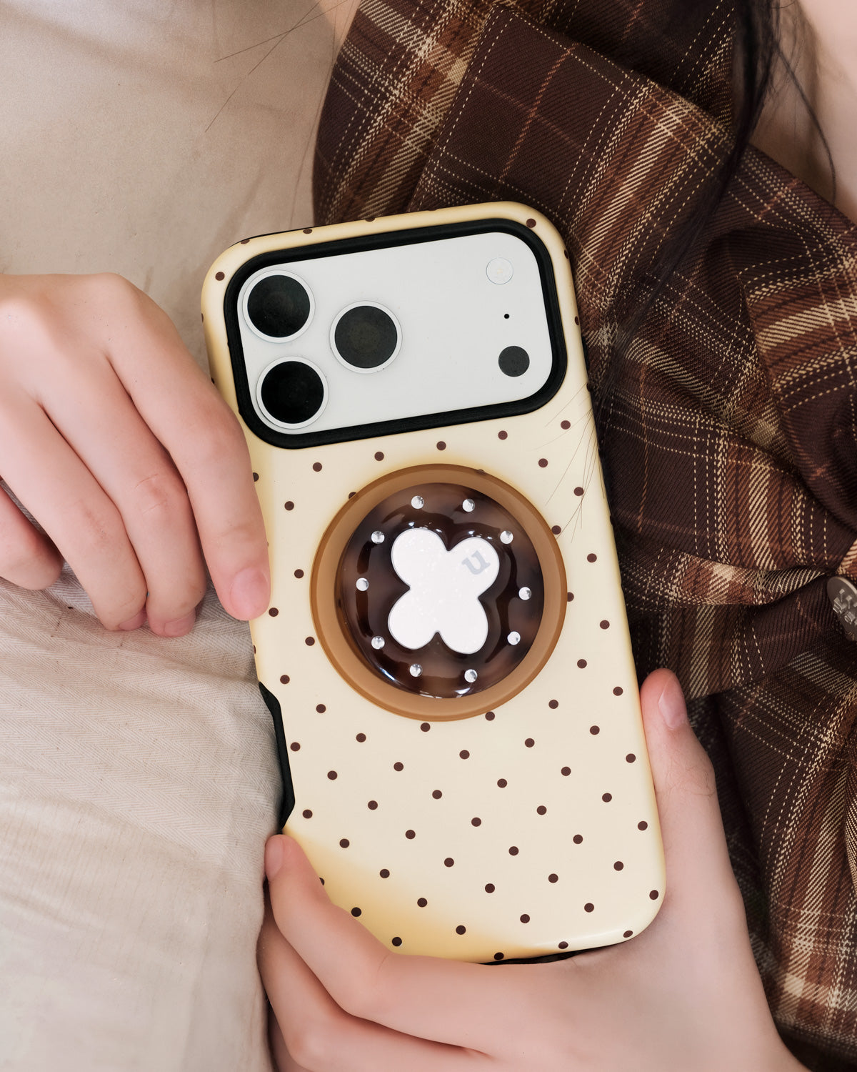 STICKYZOO lucky clover phone case held in hand with the retractable MagSafe grip popped out