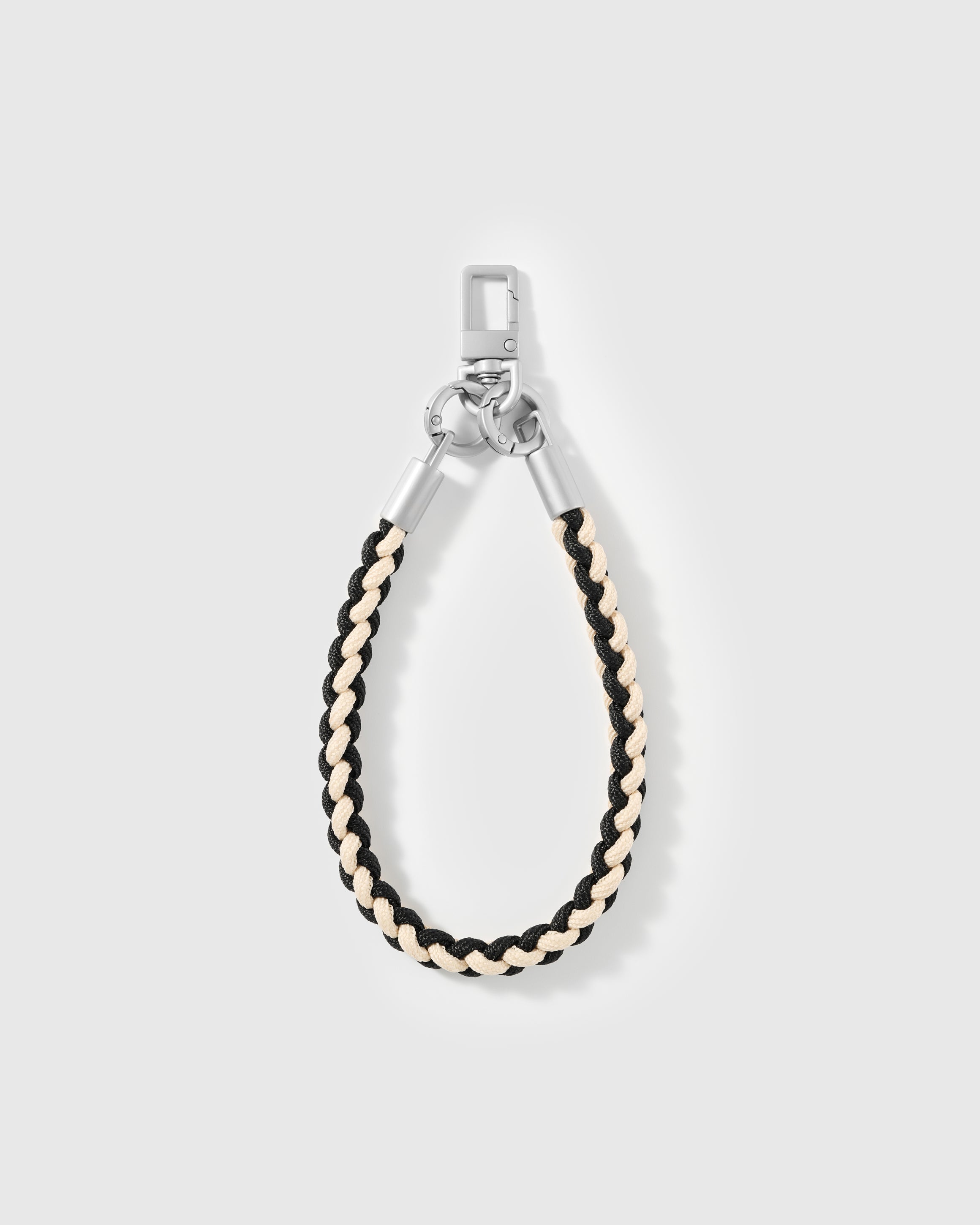 Detail of the black and cream braided accent on the STICKYZOO cross-body phone strap