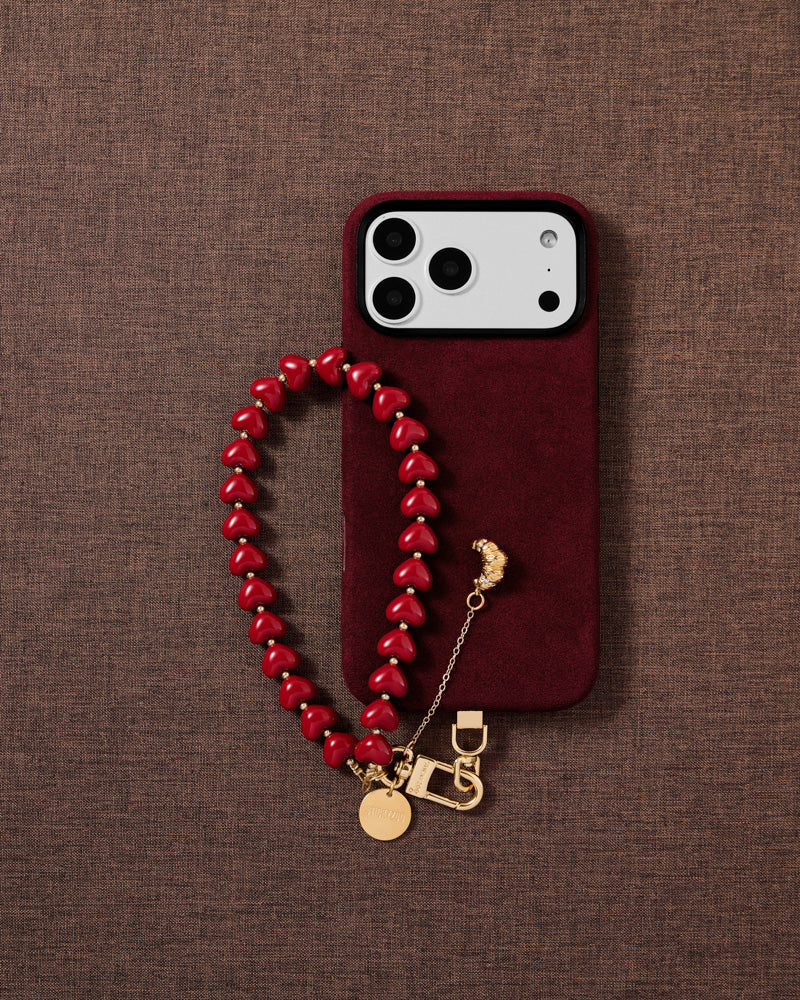 STICKYZOO cherry croissant heart phone strap on warm flat-lay — Designed in Amsterdam