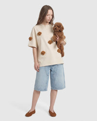 Model wearing cream STICKYZOO Poodle Parade T-Shirt holding a real poodle showing plush appliques