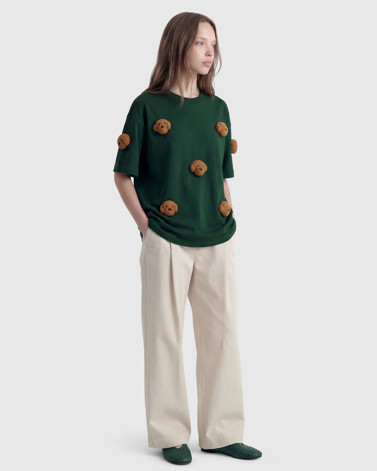 Model in green Poodle Parade T-Shirt with hand in pocket showing relaxed silhouette