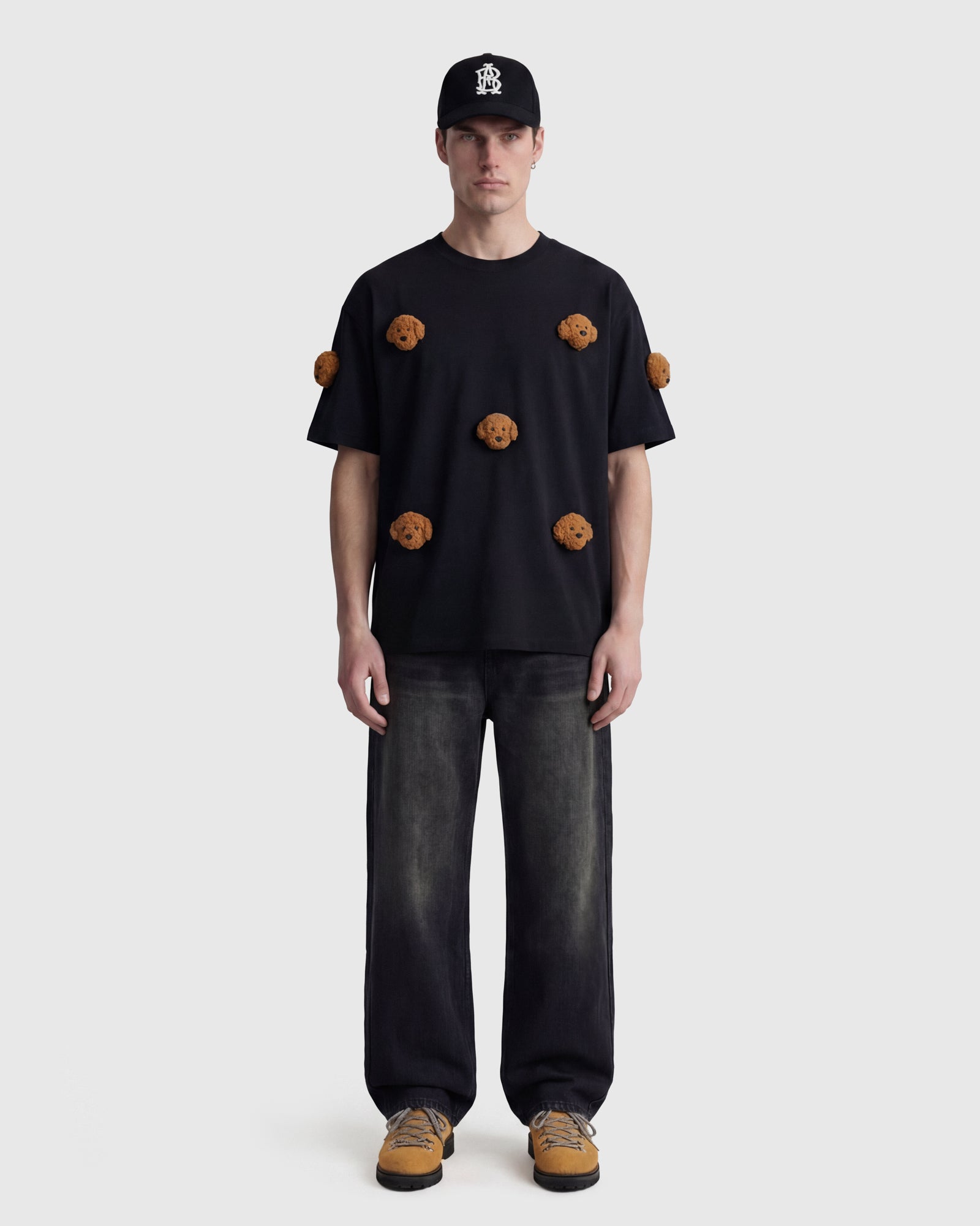 Model in black Poodle Parade T-Shirt front view showing all seven plush poodle appliques