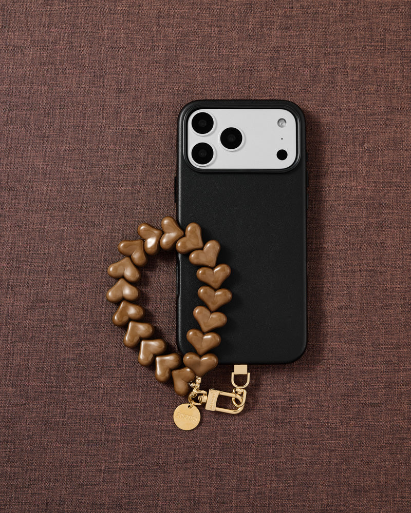 Caramel heart phone strap styled flat-lay — beaded wristlet designed in Amsterdam