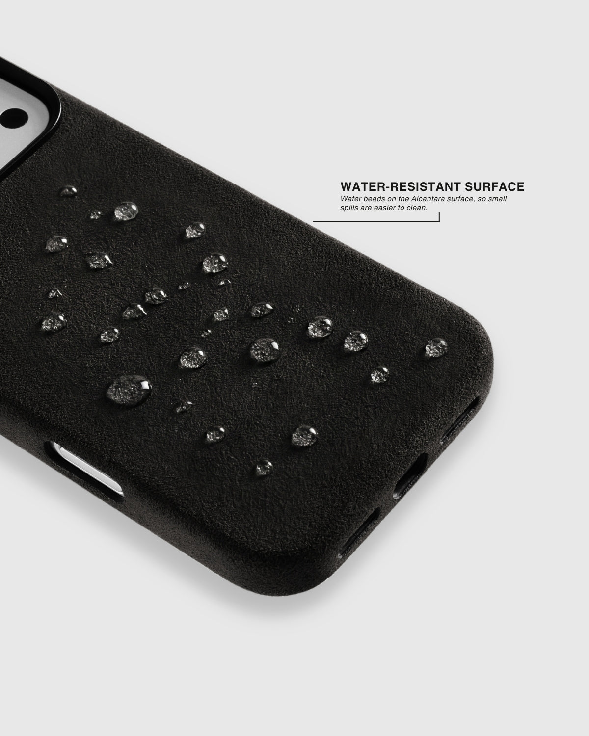 {{Light splash-resistant}} Water droplets beading on deep black Alcantara phone case surface by STICKYZOO