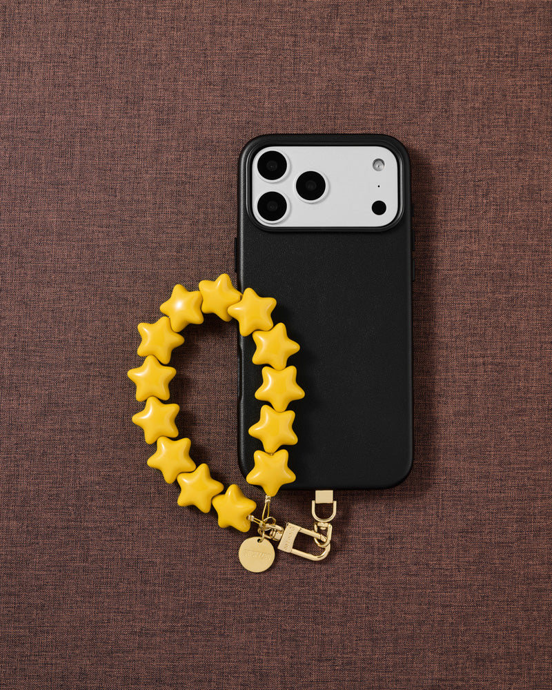 STICKYZOO honey-gold star phone strap on warm flat-lay — Designed in Amsterdam