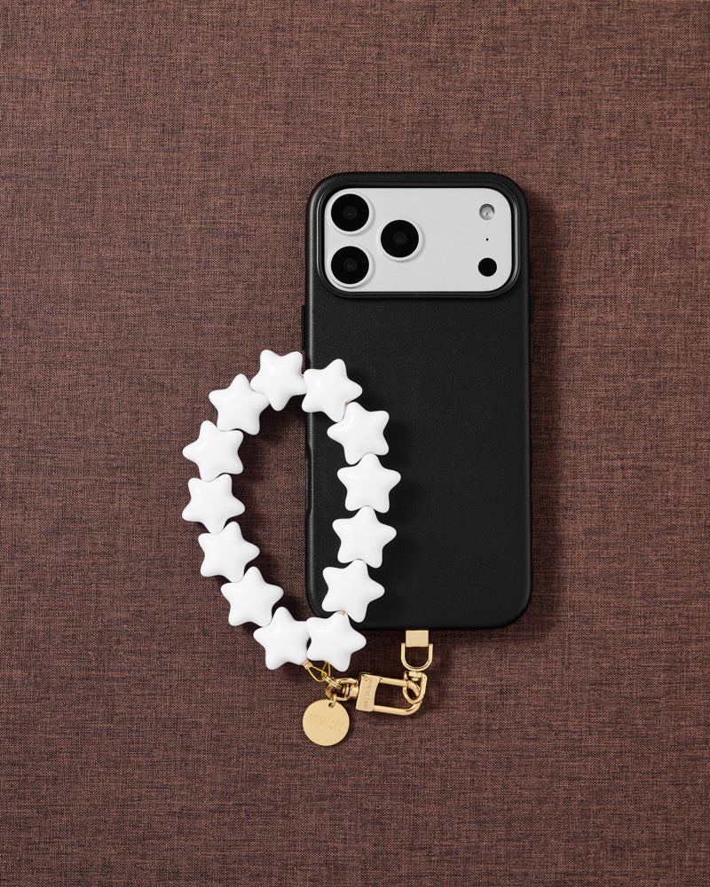 Ivory star phone strap styled on textured warm mauve fabric — Designed in Amsterdam by STICKYZOO