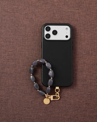 Storm agate phone strap flat-lay on dark brown fabric by STICKYZOO