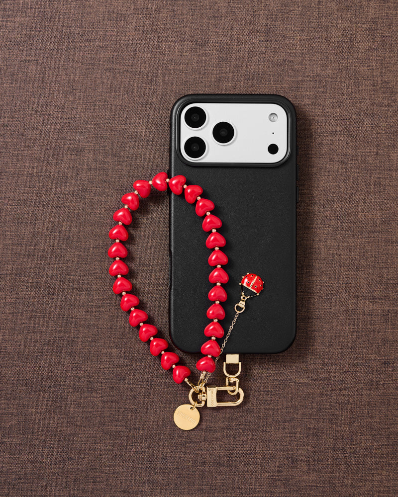 Crimson ladybug heart phone strap flat-lay — Designed in Amsterdam