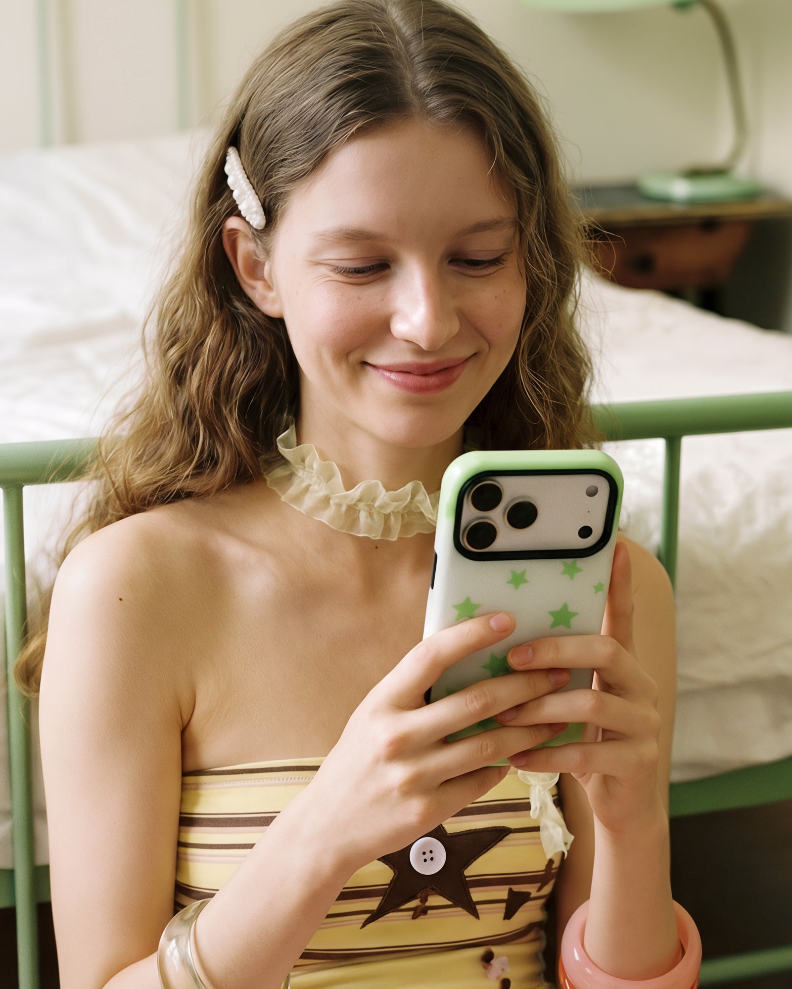 STICKYZOO green star phone case held while scrolling, the pop-grip folded flush so wireless charging still works.