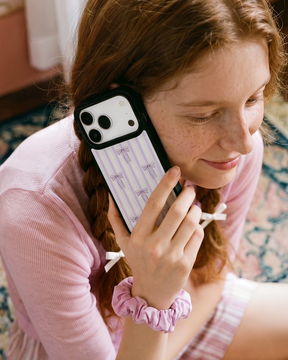 Slim framed tuxedo cat phone case in everyday use with the MagSafe grip folded flat against the bow pinstripe back