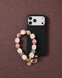 Rose marble bead phone strap with black phone case on dark fabric lifestyle flat-lay