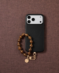 Amber swirl bead phone strap styled on fabric, loved by thousands of STICKYZOO customers